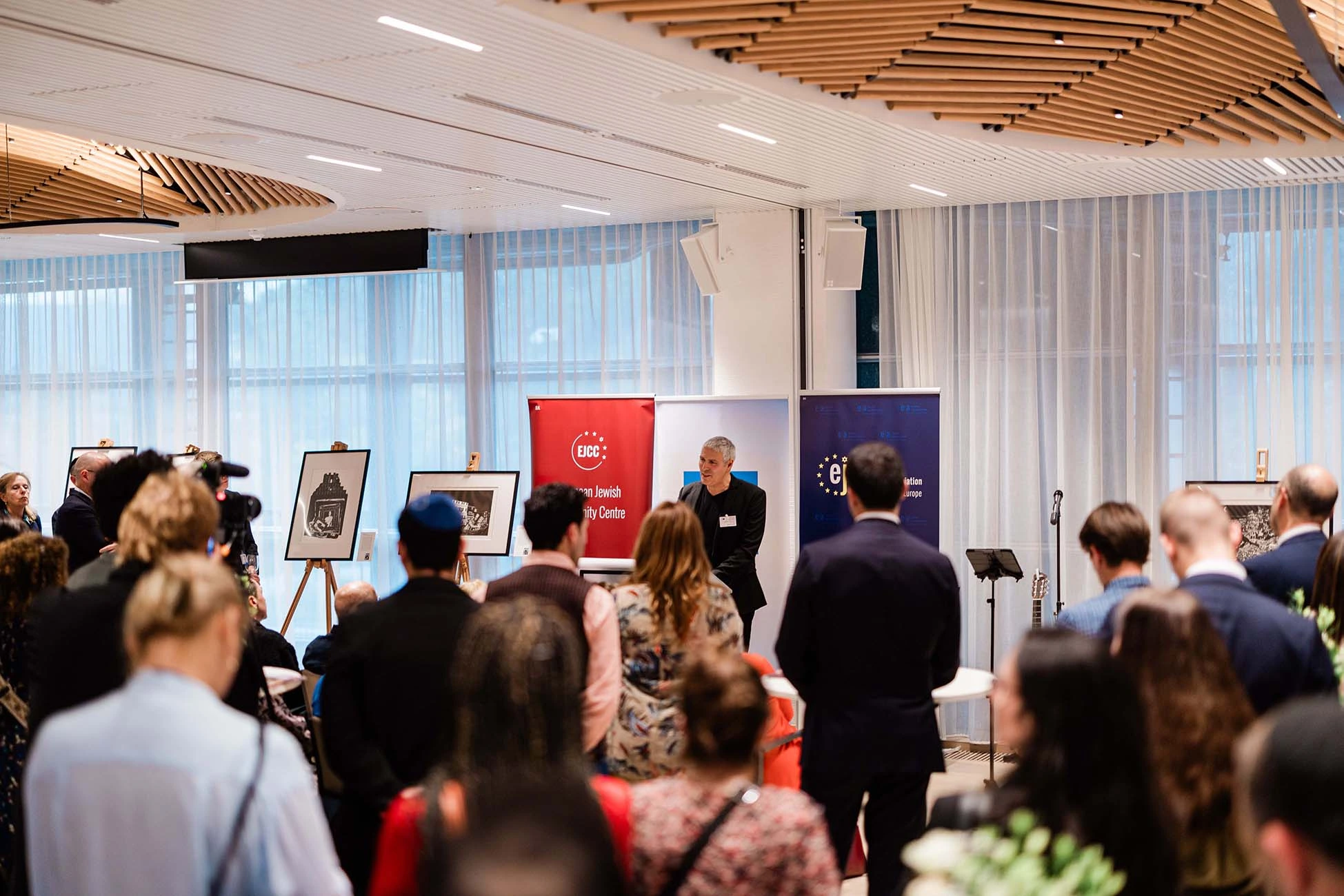 Audience facing the presentation and displayed works